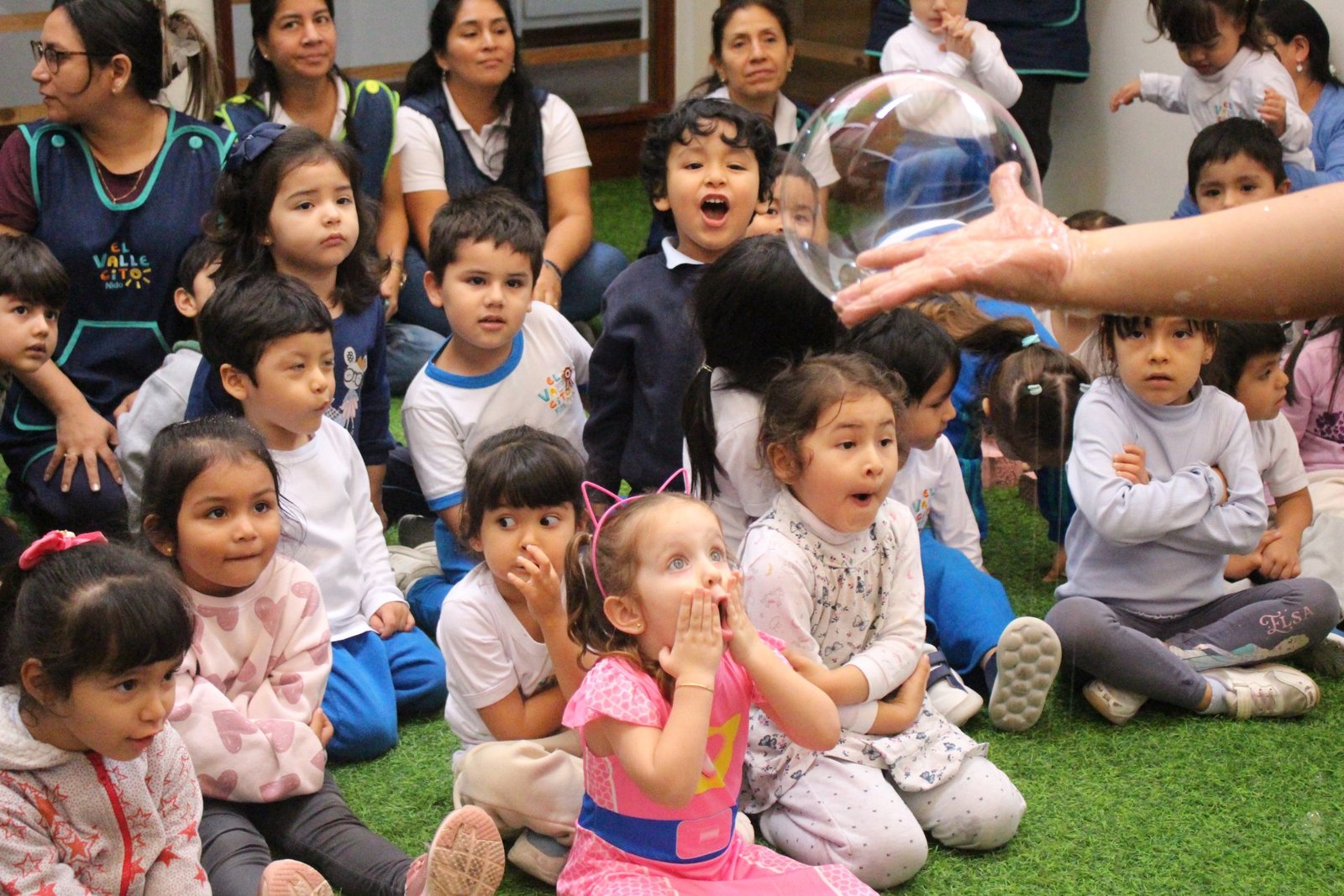 Caras de niños mirando con asombro el show de burbujas y magia